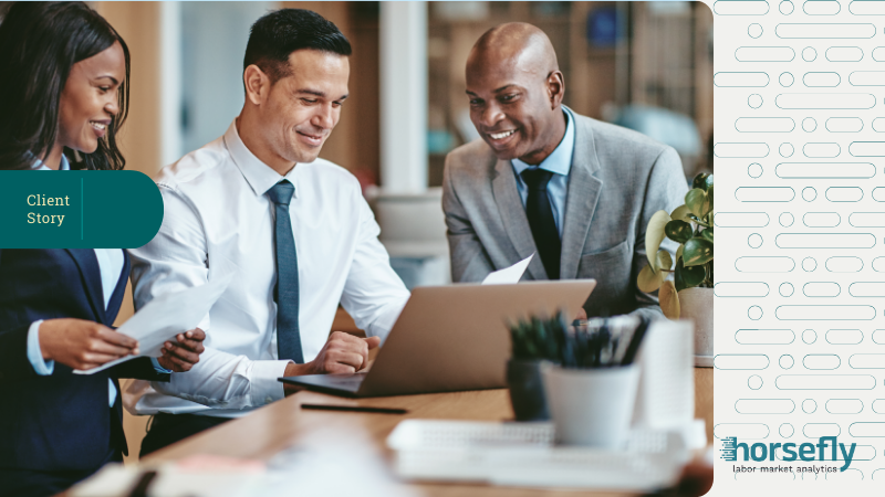 Image shows three business people looking over documents together