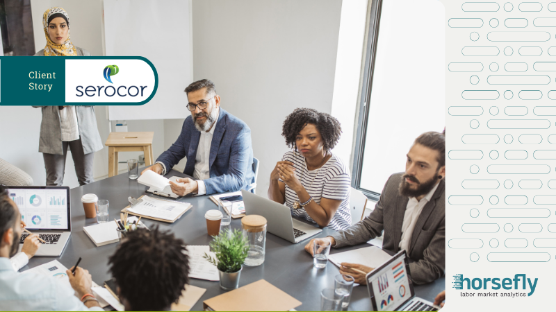 Image shows business people sat around a table in a meeting