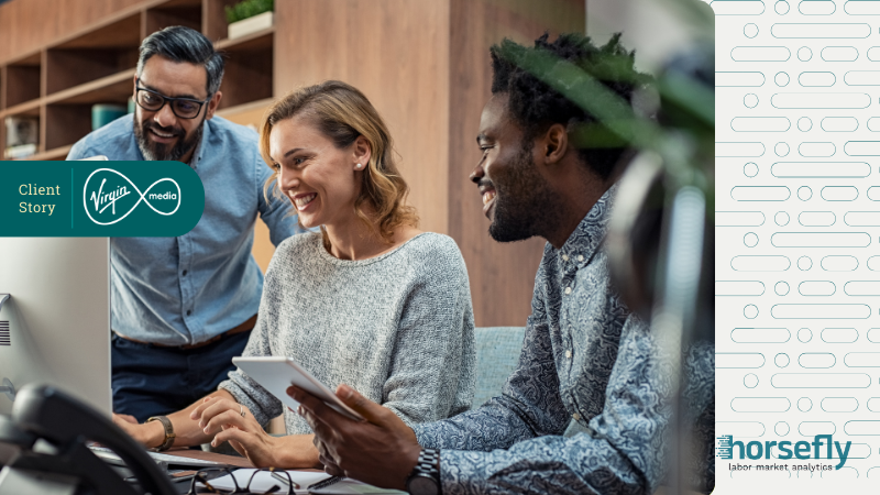 Image shows three people working together over a laptop