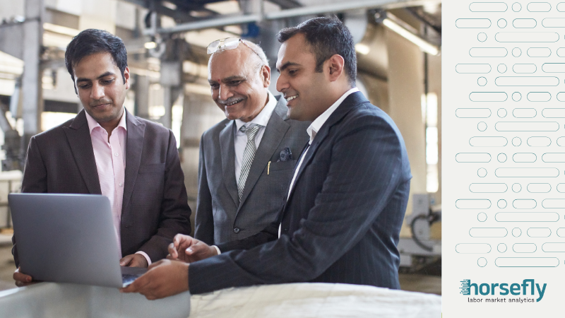 Image shows a group of three business men in suits looking at work on a laptop for the blog - Scenario Planning in a Rapidly Changing Market