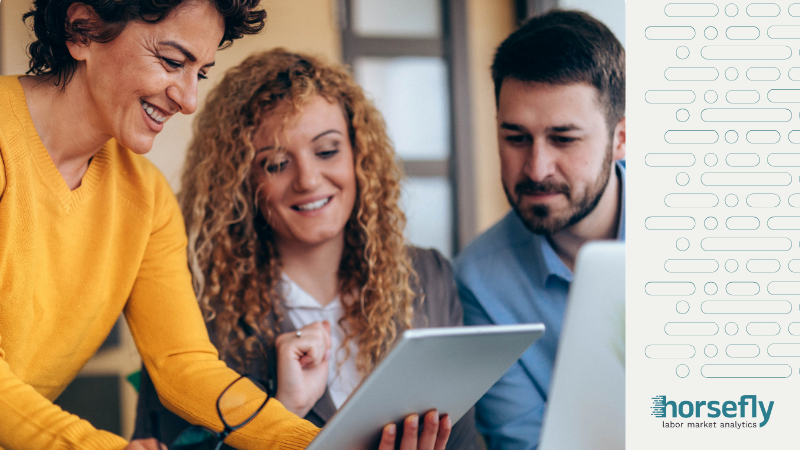 Image shows a woman showing a tablet screen to another man and woman for the blog - Big Data & Business Intelligence