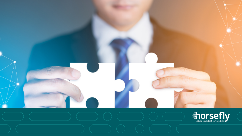 Image shows a man holding two interconnecting jigsaw pieces together for the blog - Long-term Solutions Amid Labor Shortages