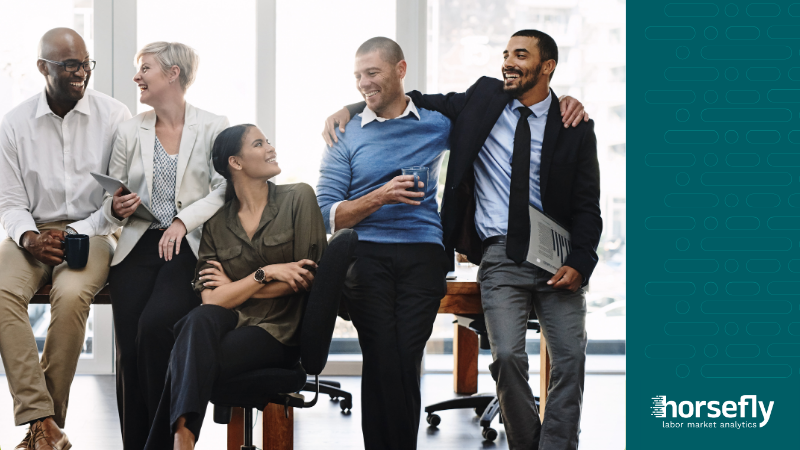 Image shows a group of happy workers chatting and laughing together for the blog - Talent Analytics: The Cheat Sheet