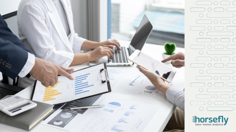 Image shows three people working with clipboard, laptop and tablet - on the blog A Strategic Approach: Leveraging Labor Market Analytics in Recruitment